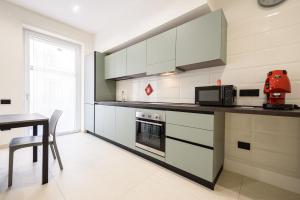 a kitchen with white cabinets and a table and a microwave at Via Niccolò Tommaseo 4 - appartamento 2 in Naples