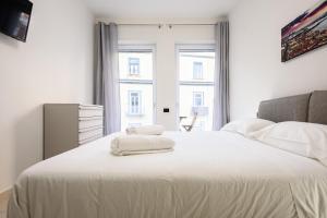 - une chambre avec un lit blanc et des serviettes dans l'établissement Via Niccolò Tommaseo 4 - appartamento 2, à Naples