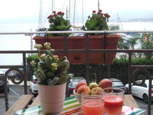 a table with a bowl of fruit and a potted plant at Bed & Breakfast Maredomus in Milazzo