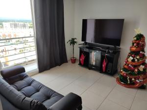 a living room with a christmas tree and a television at Habitación privada con vista a la ciudad in Pereira