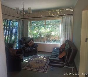 a living room with two chairs and a couch at CHEZ BRUNO in Pretoria