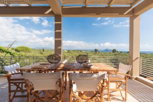 a wooden table and chairs on the deck of a house at Aelia Home Suites in Marathopolis
