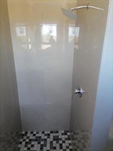 a shower stall with a black and white checkered floor at Goshen Place in East London