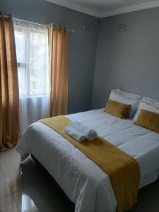 - une chambre avec un lit et 2 serviettes dans l'établissement Goshen Place, à East London