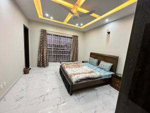 a bedroom with a bed and a ceiling fan at Bahria Residency in Rawalpindi