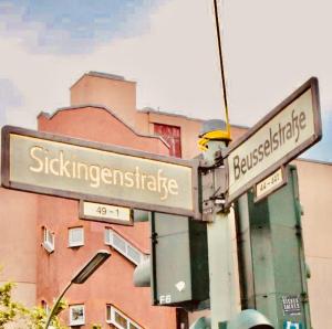 zwei Straßenschilder an einer Stange vor einem Gebäude in der Unterkunft Hotel Sickinger Hof in Berlin