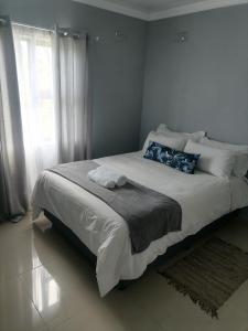 a bedroom with a large white bed with a window at Goshen Place in East London