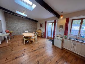 a kitchen and dining room with a table and chairs at Les Cerisiers Gîtes in Lezay