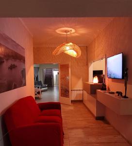 un soggiorno con divano rosso e TV di Privilegio Hostel a San Rafael