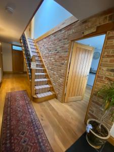 una escalera en una casa con una pared de ladrillo en Mulberry Cottage near Goodwood en Chichester