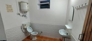 a bathroom with a toilet and a sink at UpClimb Longstay for bus or taxi only guests in Manāli