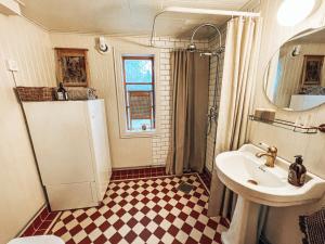 y baño con lavabo, aseo y espejo. en Taiga Forest Lodge, en Gällivare