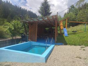 a swimming pool with a pergola and an outdoor swimming poolvisor at Pensiunea Trei brazi Scărișoara in Scărişoara