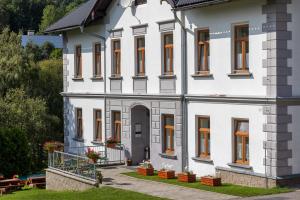 een wit huis met oranje ramen en een binnenplaats bij Apartmány U Aloise in Dolní Morava