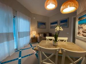 a dining room with a table and a couch at Villa Aquamarina Pintadera Rossa in Porto Pino