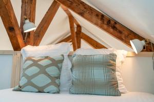2 almohadas sentadas encima de una cama en Le Sully - Beaucoup de charme à 100m du château, en Pau