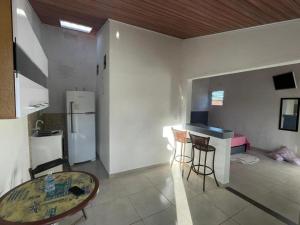 a kitchen with a refrigerator and a table in a room at Casa na Orla - Praia de Gaibu! in Cabo de Santo Agostinho