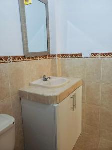 ein Bad mit einem Waschbecken und einem Spiegel in der Unterkunft Casa MANCORA in Máncora