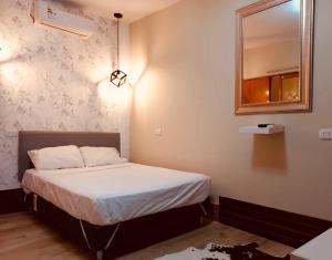 ein kleines Schlafzimmer mit einem Bett und einem Spiegel in der Unterkunft Casa MANCORA in Máncora