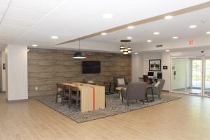 een lobby met een tafel en stoelen en een tv bij Candlewood Suites Tallahassee, an IHG Hotel in Tallahassee