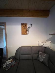 un sofá en una sala de estar con un reloj en la pared en BergNest Ferienhäuser "Haus mit Herz" en Arnoldshammer