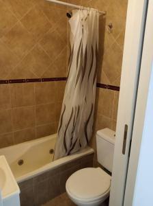 y baño con aseo y cortina de ducha. en Nada en Buenos Aires