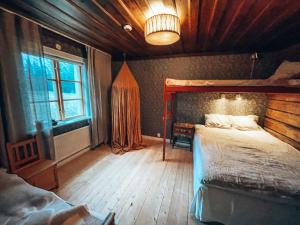 um quarto com uma cama grande e uma janela em Taiga Forest Lodge em Gällivare