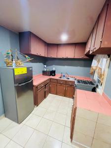 a kitchen with wooden cabinets and a stainless steel refrigerator at Bahia Azul Apartment in Six Huts