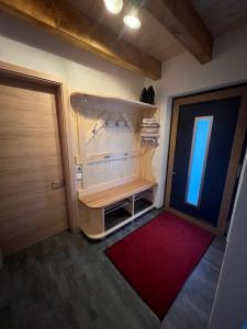 um pequeno quarto com uma porta e um tapete vermelho em BergNest Ferienhäuser "Haus mit Herz" em Arnoldshammer