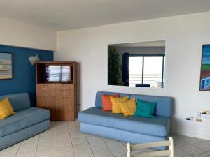 Pampatar的住宿－Bahia Dorada 1 habitación，客厅配有2张蓝色沙发和镜子