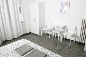 a white room with a table and chairs and a table and a bed at La Pergola in Vezzano Ligure