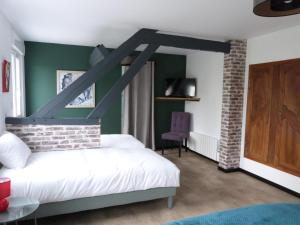 a bedroom with a white bed and green walls at Aux Portes des Lacs in Ardres