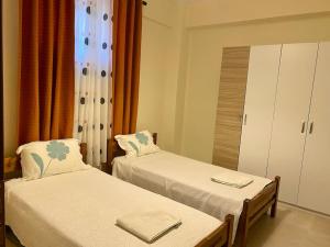 Pokój z 2 łóżkami, szafką i oknem w obiekcie DS Apartment (semi-basement) w Atenach