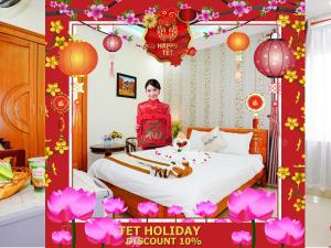 Eine Frau steht auf einem Bett in einem Zimmer in der Unterkunft Thành Hoàng Châu Hotel in Đà Nẵng