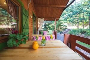 a wooden table on the porch of a house at Domki KOLONIA LEŚNA z sauną i gorącą balią in Radków