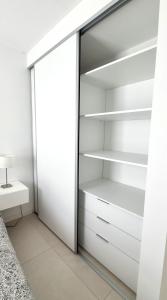 a closet with white shelves and a bed at NidoAparte II. Nuevo departamento en Lujan Centro in Luján +25 photos