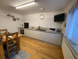 a kitchen with a counter and a table in a room at Mulberry Cottage near Goodwood in Chichester