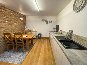 a kitchen with a table and a brick wall at Mulberry Cottage near Goodwood in Chichester