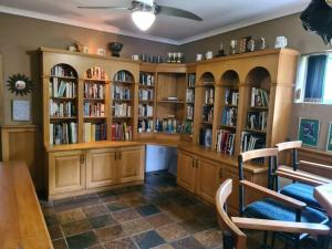 una biblioteca con estanterías de libros de madera llenas de libros en The Missing Link A place you've been searching for, en Umtentweni
