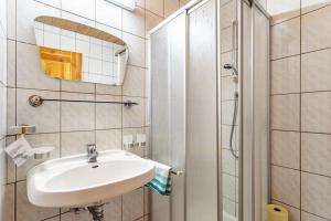 a white bathroom with a sink and a shower at Schwüwong - Apartment 23 in Kelchsau