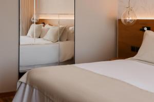 a bedroom with a white bed and a mirror at Cottage Carrasco in Montevideo