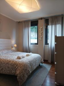 a bedroom with a bed and two windows at Apartamento Piscina 1G by Urraca Suites Viveiro in Viveiro