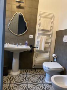 a bathroom with a sink and a toilet and a mirror at Borgogna 14 in Reggio Emilia