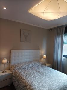 a bedroom with a large bed with a white headboard at Apartamento Piscina 1G by Urraca Suites Viveiro in Viveiro
