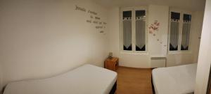 セル・シュル・シェールにあるMaison de villeのベッド2台と窓2つが備わる小さな客室です。