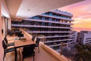 a balcony with a table and chairs and a building at Ocean view 4 min walk to Medano Beach in Cabo San Lucas