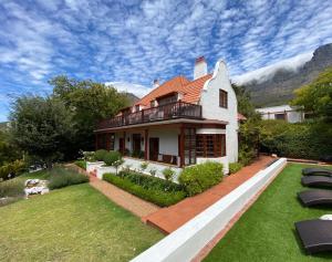 a house with a balcony and a yard at Acorn House in Cape Town