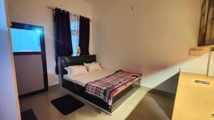 a small room with a bed and a television at Mango Villa in Guwahati