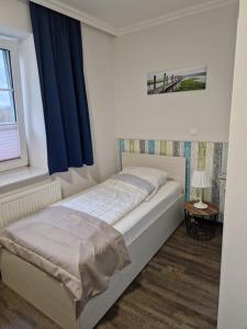 a bedroom with a large bed with blue curtains at Gästequartier Schlummerkasten in Sievern