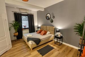 a bedroom with a bed with orange pillows and a window at Dwór Konstancin in Konstancin-Jeziorna